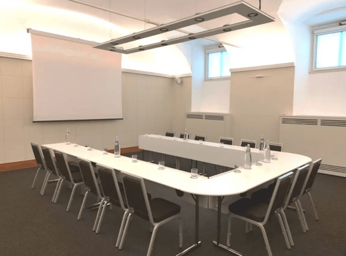 Vaulted Minimalist Room With Soft Uplighting for Leadership Briefings