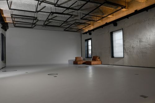 Industrial Concrete Studio With Cyclorama Wall and Rigging Grid for Creative Events