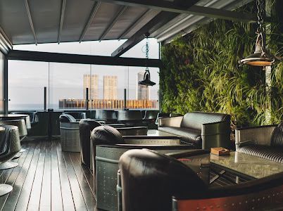 Industrial Rooftop Lounge With Green Wall and City Views