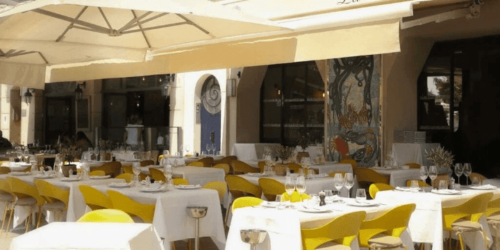 A charming outdoor space for brunch in Cannes with a large awning and vibrant decor.jpg
