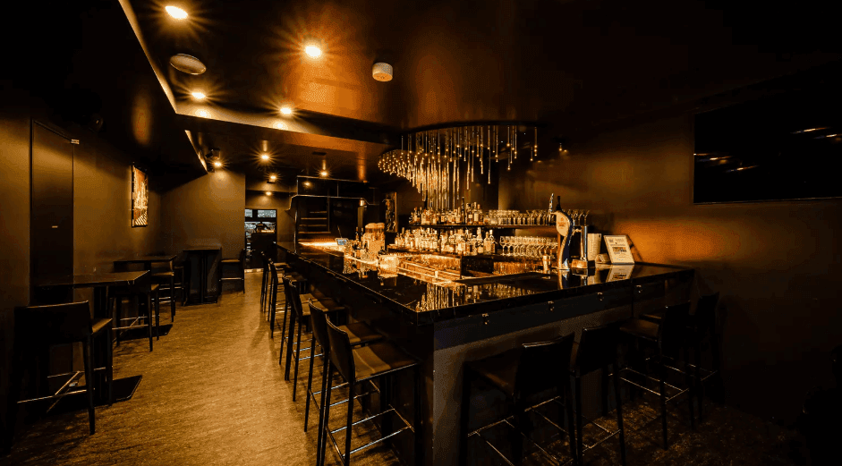 A moody black after-work bar venue in Tokyo with luxe lighting and a gorgeous terrace.png