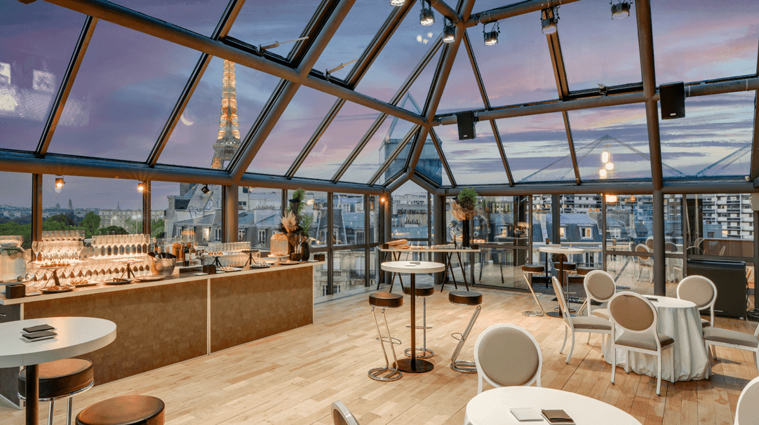 A stunning French dinner party venue with a glass atrium and panoramic city views.png