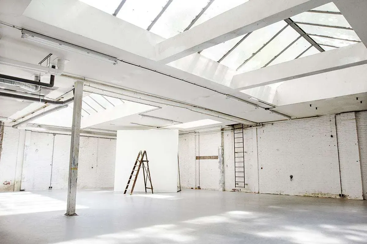 A bright exhibition location in an industrial space with skylights.webp