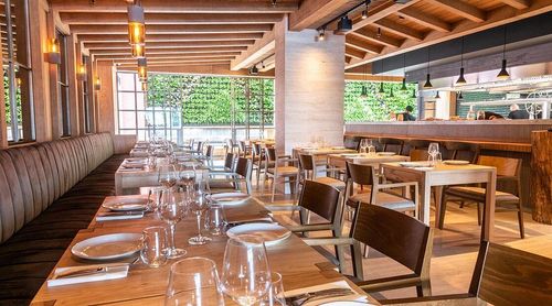 Warm Timber-Lined Restaurant With Leather Banquette and Sunlit Glow for Executive Dinners