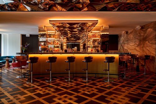 Opulent Cocktail Bar With a Reflective Geometric Ceiling for Upscale Soirees