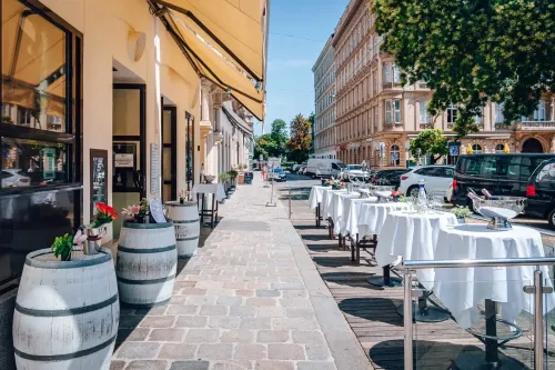 Outdoor Terrace With Glass Railing and Barrel Tables for After-Work Drinks