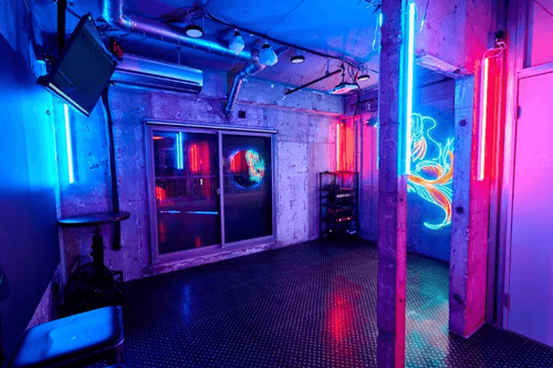 Neon-Illuminated Industrial Bar With Raw Concrete Walls and Cityscape Views for Bold Parties