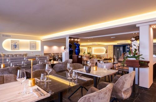 Minimalist White Restaurant With Marble Tables and Cosy Booths for Intimate Dinners and Corporate Gatherings