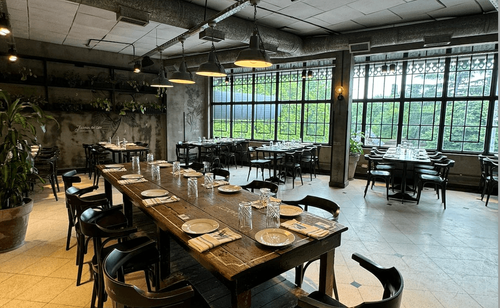 Industrial-Chic Dining Setting With Floor-To-Ceiling Windows and Urban Ambience