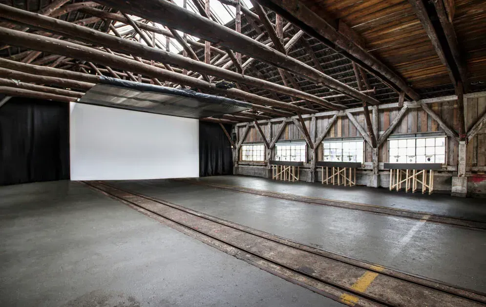 A warehouse venue hire with exposed timber and vintage rail tracks.webp