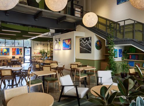 Modern Café With High Ceilings and Vibrant Artwork for Client Lunches and Meetings