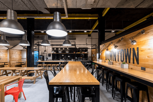 Industrial Workspace With Wooden Booths and Communal Tables for Team Sessions