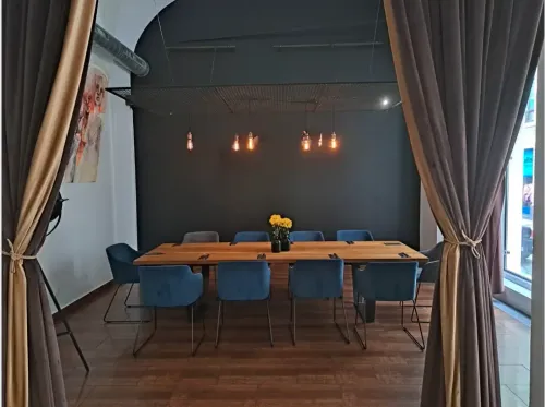 Charcoal-Walled Private Dining Room With Edison Bulbs & Teal Velvet Chairs for High-End Dinners and Tastings