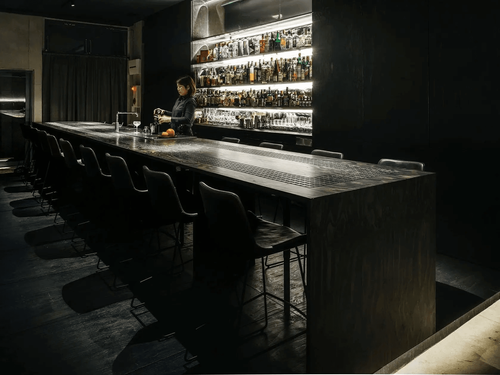 Sleek Underground Bar With Dark-Wood Charm and Backlit Bar for Exclusive Cocktail Parties