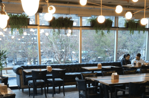 Modern Industrial Dining Spot With Greenery and Flexible Table Layouts