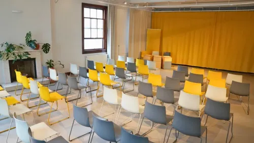 Eclectic Studio With Tall Windows and Projector Screen for Team Workshops