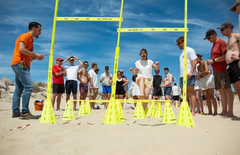 Beach‑court challenge—mid‑retreat energy boost—teammates cheer as the course gets real. (Source- Eventflare).jpg