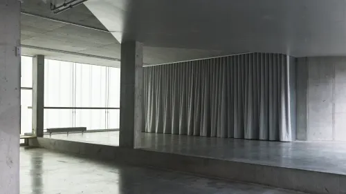 Minimalist Concrete Loft With Curved Ceiling and Terrace Access for Wellness Gatherings