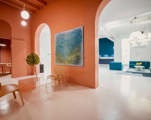 Vibrant Industrial Space With Coral Walls and Teal Furnishings for Inspiring Networking
