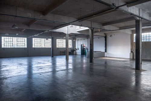 Industrial Upper-Floor Hall With Raw Finishes and Modular Layout for Workshops