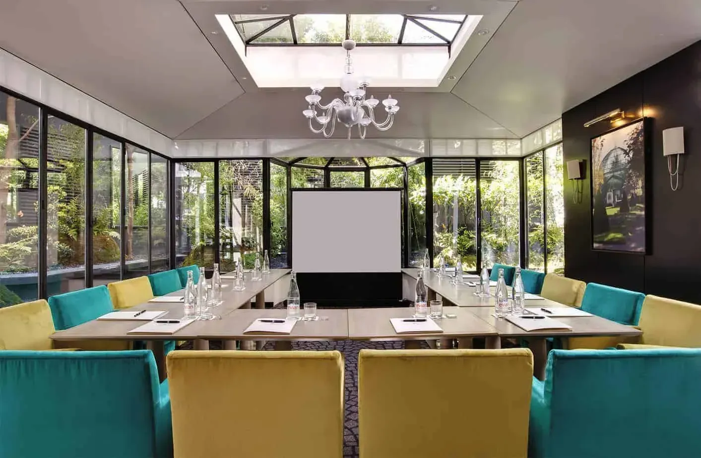 Elegant glass room with a chandelier surrounded by a serene Japanese garden in Paris.webp