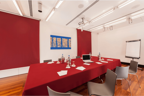 Minimalist Executive Room With Bold Red Accents and Graphic Decor for Team Briefings